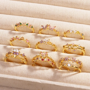 Vue détaillée de l'ensemble de 9 bagues dorées avec zircons colorés et motifs papillon
