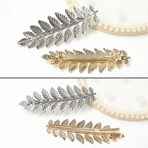Detailed view of alloy leaf hair clips in gold and silver finish with realistic leaf texture