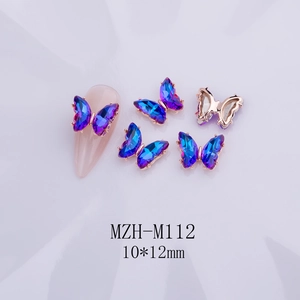 Detalle de dijes para uñas de mariposa de cristal 3D en morado con base de metal oro