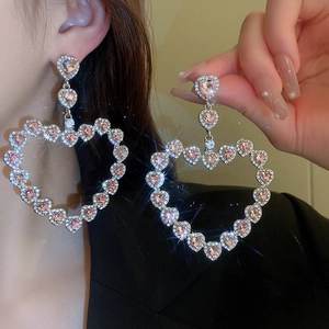 Macro detail of layered heart earrings with sparkling pink crystals and silver rhinestones