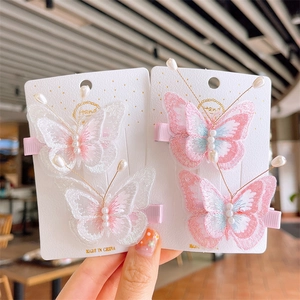 Hand holding white and pink butterfly lace embroidery hair clips with faux pearls