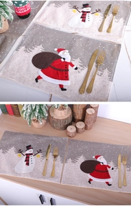 Detail of Christmas placemats with Santa and snowman patterns in linen texture