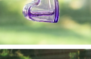 Close-up of purple heart-shaped glass aromatherapy bottle with a decorative wooden cap