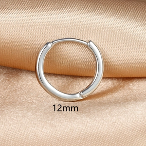 Macro detail of a 12mm silver hoop earring on a luxury champagne silk background