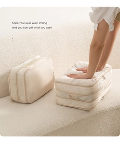Détail montrant la compression manuelle sur le sac de rangement voyage blanc crème