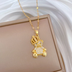 Detailed macro of a gold bear crown necklace with zircon inlay on beige display box