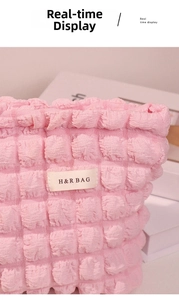 Primer plano de bolsa de cosméticos rosa con textura de burbujas y etiqueta tejida