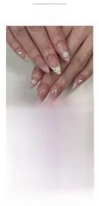 Detail of pink French press-on nails with 3D white roses, pearls and ribbon bows