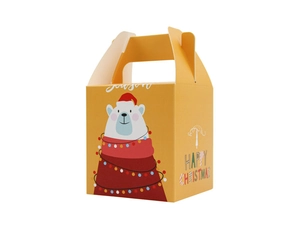 Détail d'une boîte cadeau de Noël jaune avec un ours polaire et des lumières festives