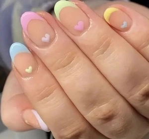 Detail of French press-on nails with pastel macaron tips and tiny heart accents