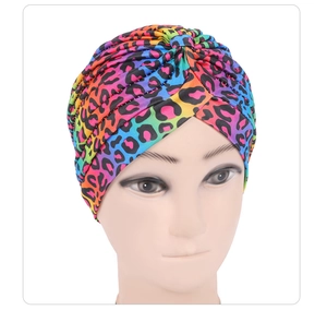 Detailed view of colorful leopard print turban hat with elegant pleated texture on a model
