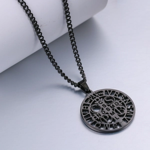 Detailed view of black stainless steel St. Benedict medal necklace on a white prop stand