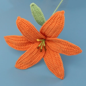 Detailed close-up showing the knit texture and craftsmanship of a handmade orange yarn lily
