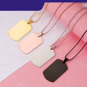 Detail view of four stainless steel dog tag pendants in gold, rose gold, silver, and black
