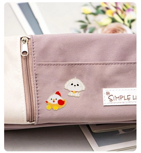 Detail of canvas pencil case with cute chick and dog charms and Simple Life label