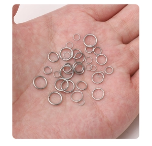 Macro shot of silver stainless steel jump rings in hand showing various sizes for DIY jewelry