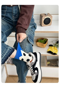 Close-up of blue and white polka dot cotton crew socks worn with jeans and white sneakers
