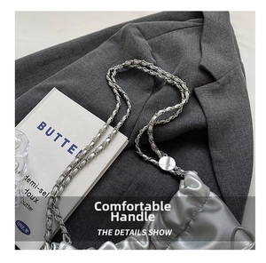 Detail view of the silver pleated cloud bag with metallic chain and leather texture