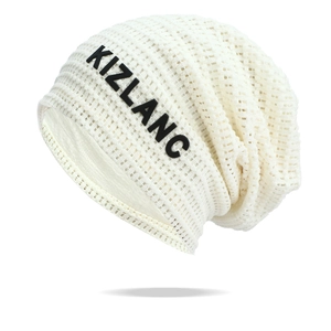 Detail of white mesh knit beanie showing black KIZLANC logo and breathable texture
