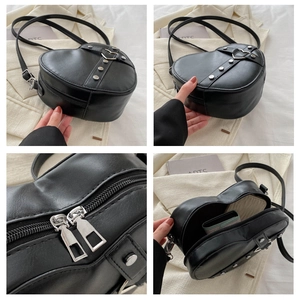 Détails du sac à bandoulière noir en forme de cœur avec clous argentés et double zip