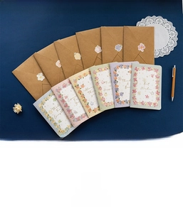 Detail of 3D floral greeting card set with kraft envelopes and stickers on blue background