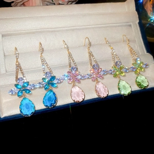 Detail view of flower and waterdrop zircon earrings in blue, pink, and green colors