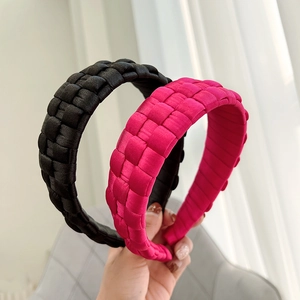 Detail of hand-woven thick headbands in black and fuchsia satin with checkered texture