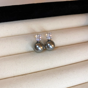 Gros plan de boucles d'oreilles perles grises avec clous carrés sertis de zircons