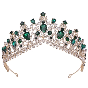 Close-up of golden bridal tiara with emerald crystals and sparkling rhinestones