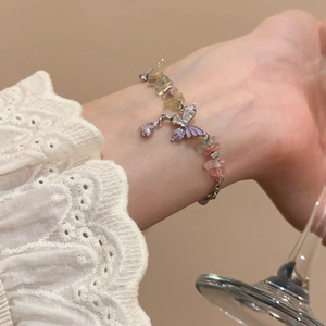 Detailed close-up of butterfly bracelet with colorful natural stones and zircon charms