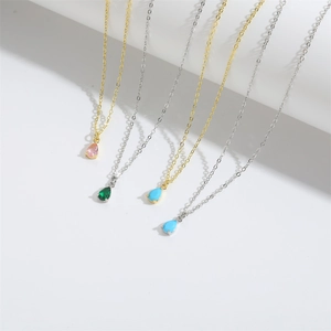 Detailed view of teardrop pendant necklaces in gold and silver with colorful gemstones