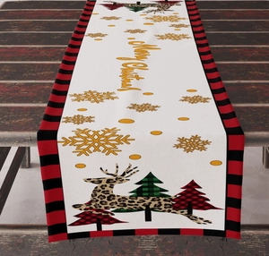 Detail of linen table runner featuring reindeer, Christmas trees and Merry Christmas text