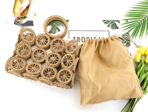 Detail of woven straw bag with hollow circular patterns and drawstring linen inner pouch