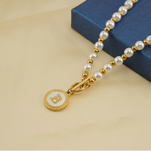Detail of 18K gold-plated OT buckle necklace with pearl beads and letter B pendant
