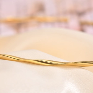 Elegant 18K gold plated twisted necklace showcasing refined texture on beige silk