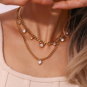Close-up of gold plated Cuban chain necklace with sparkling zircon pendants on a model