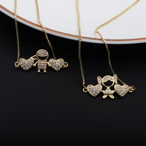 Detailed close-up of gold-plated boy and girl pendants with sparkling crystal hearts