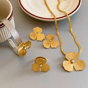 Elegant gold titanium steel jewelry set featuring clover necklaces rings and earrings