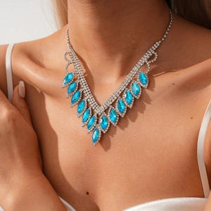 Detailed view of silver V-shaped tassel necklace with sparkling sky blue gemstones