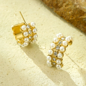 Gold C-shaped hoop earrings with rows of white pearls and sparkling cubic zirconia