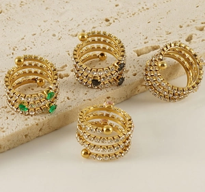 Detail of multi-layer spiral rings with colorful zircon stones in gold finish