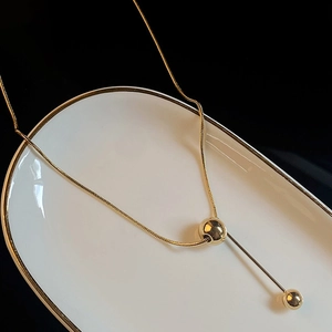 Minimalist gold titanium steel necklace with a double bead pendant on a snake chain
