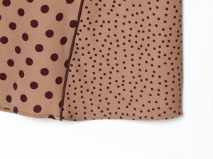 Detail of brown polka dot midi dress showing fabric texture and fine stitching
