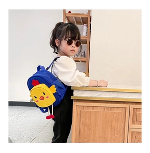 Blue canvas toddler backpack with yellow 3D chicken pocket worn by a little girl