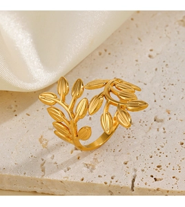 Detail of a golden leaf-shaped ring showing intricate branch textures and adjustable band