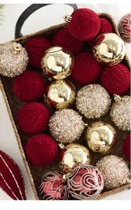 Assortiment de boules de Noël en velours rouge foncé et paillettes dorées en panier