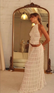 Close-up of white two-piece set featuring halter neck top and layered tiered maxi skirt