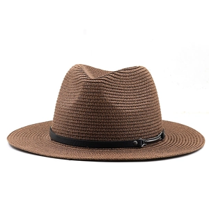 Close-up of brown straw fedora featuring dense weaving and black leather strap detail