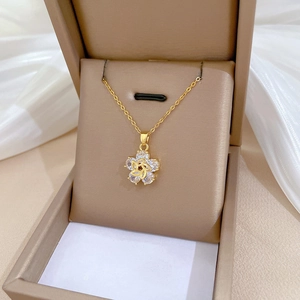 Luxury rotating flower necklace with shimmering crystals in a beige jewelry box