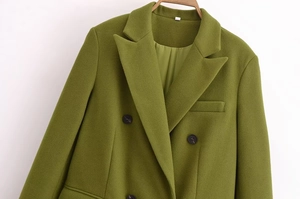 Dettaglio di un cappotto di lana verde oliva a doppio petto con revers classici e tasche